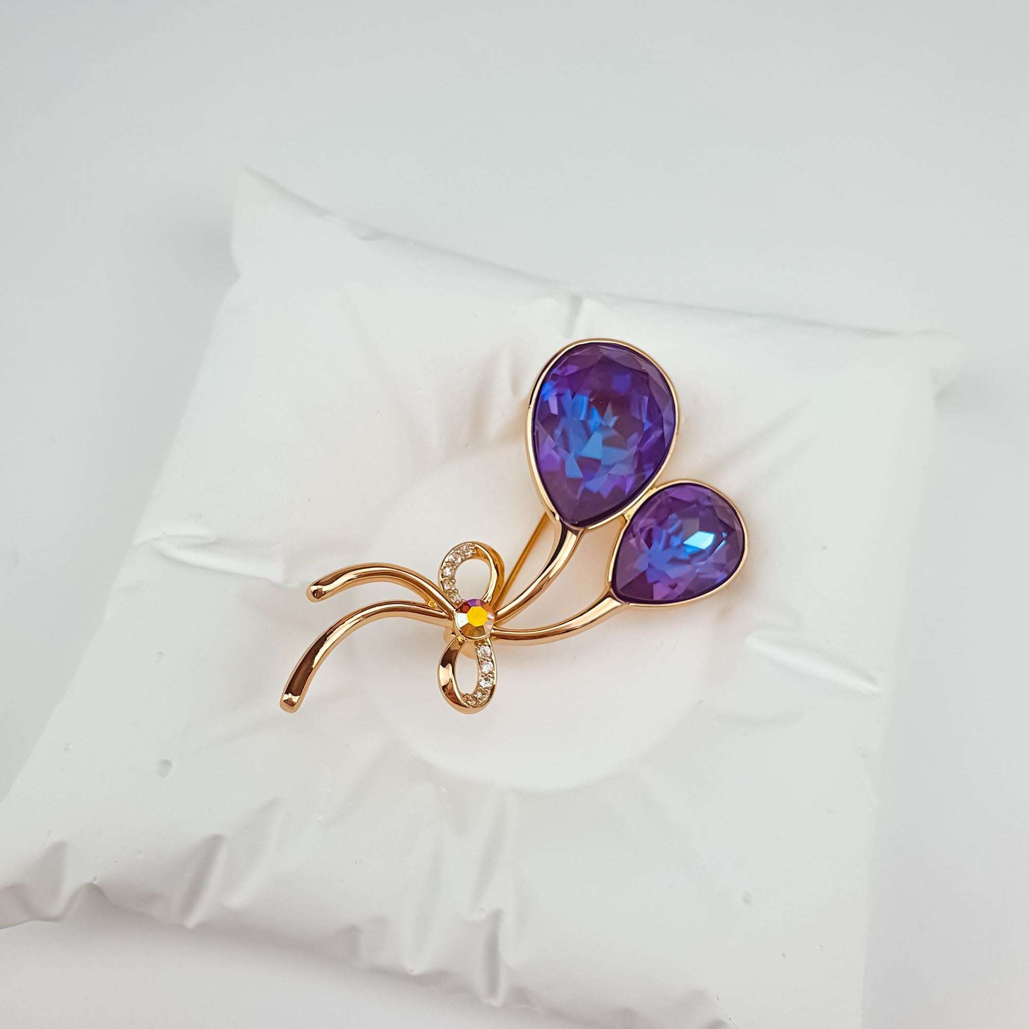 Eleganta apzeltīta piespraude ar violetiem Swarovski akmeņiem