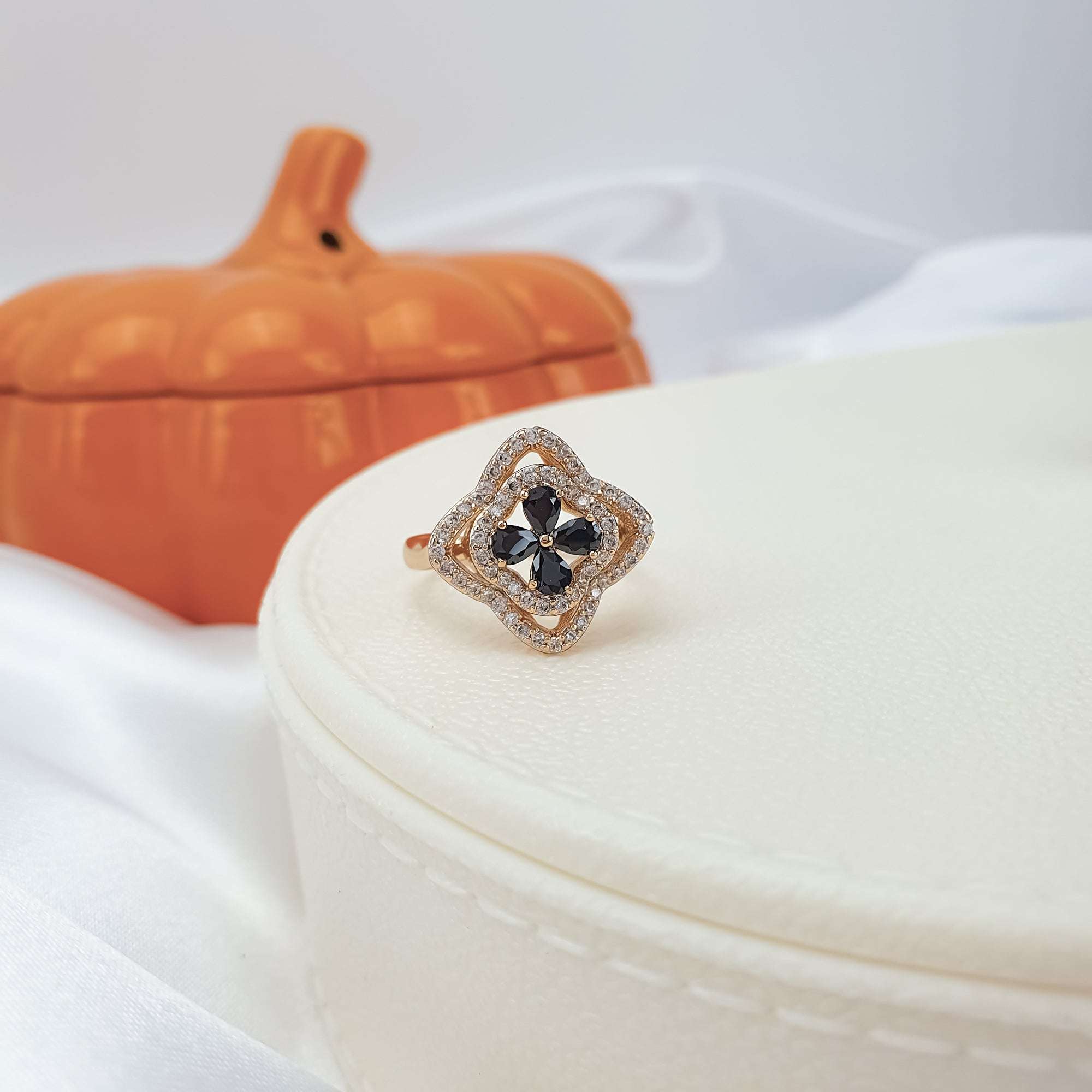 Gredzens ar melno ziedu un baltu mirdzumu