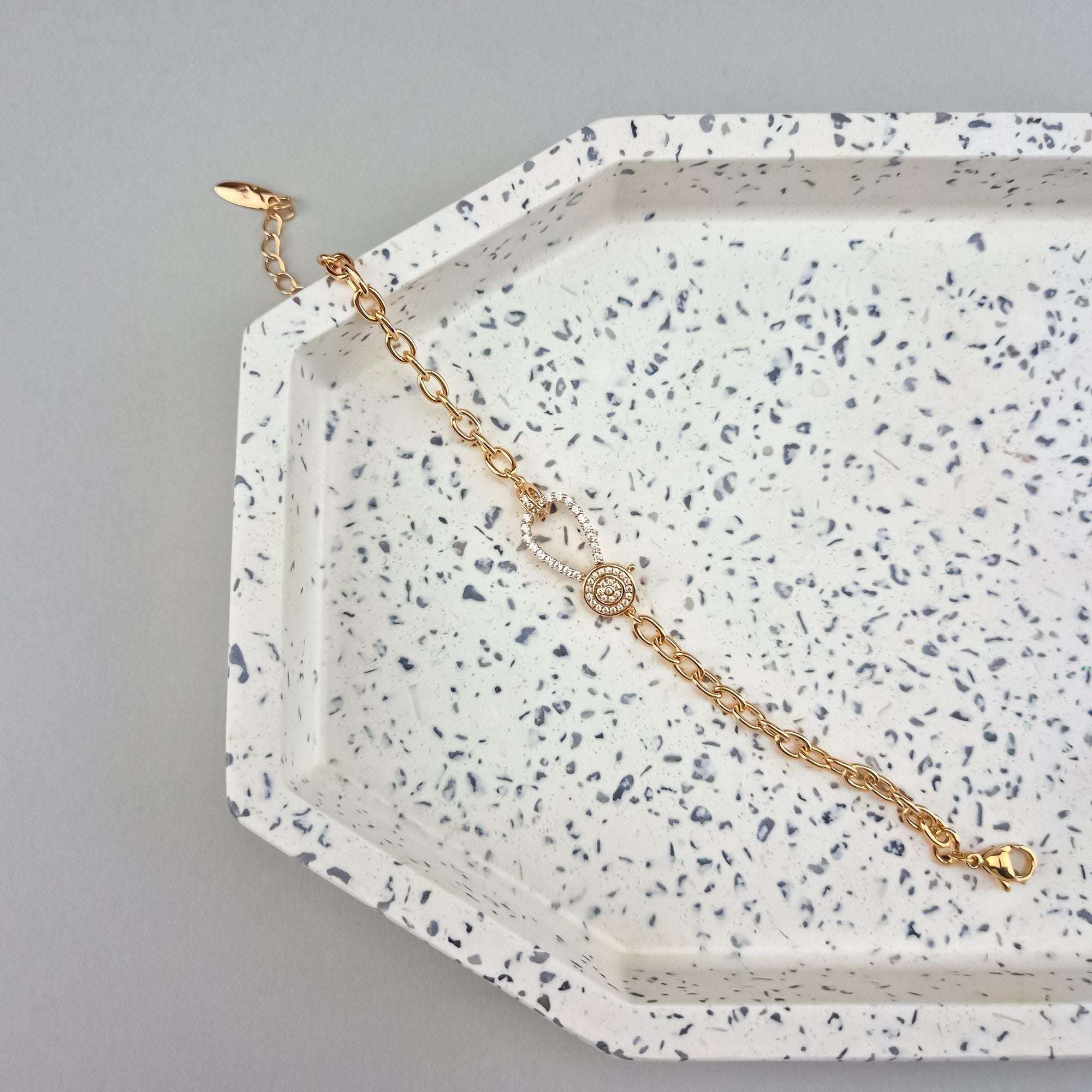 Stilīga zelta rokassprādze ar dekoratīvu aizdari un ķēdes pinumu