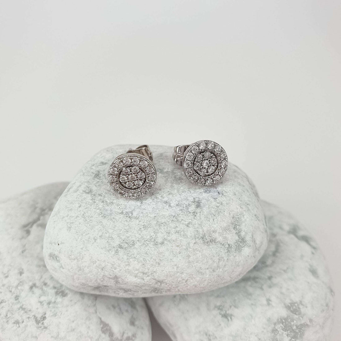Tsirkoonirosetiga kõrvarõngad valgetel veeriskividel, selgelt on näha mugav naastkinnis