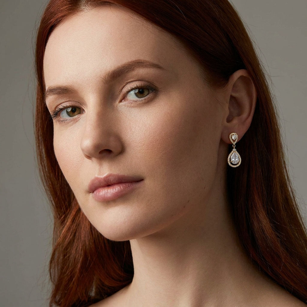 Модель носит позолоченные серьги-капли с цирконами, мерцающие рядом с лицом