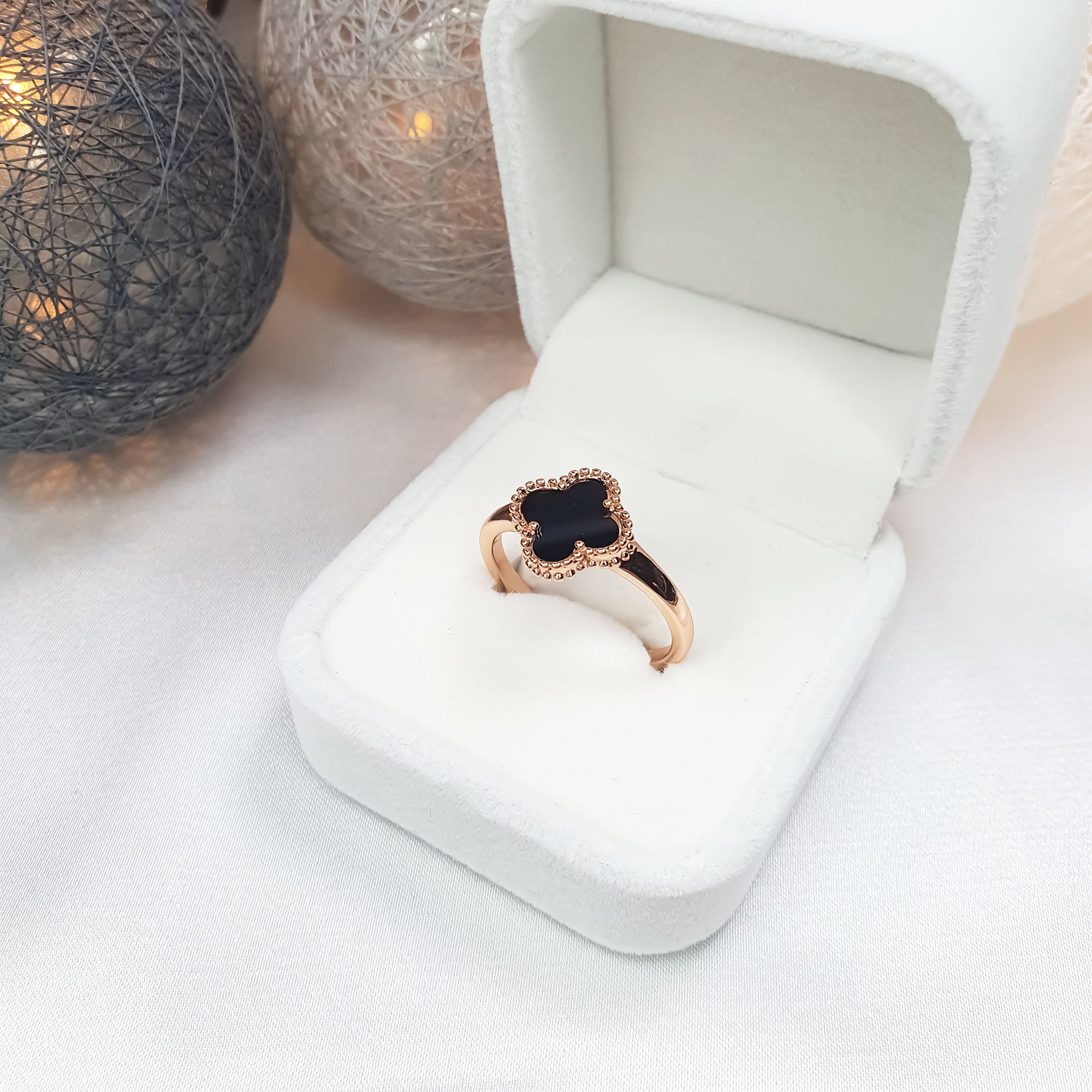 Gredzens ar spīdīgu melno āboliņa akcentu zelta tonī