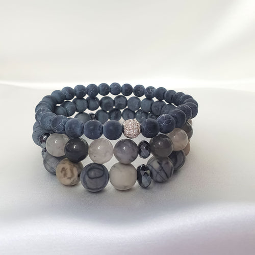 Pērļotas rokassprādzes pelēkos toņos ar mirdzošu centrālo lodi un šķautņainiem akmeņiem