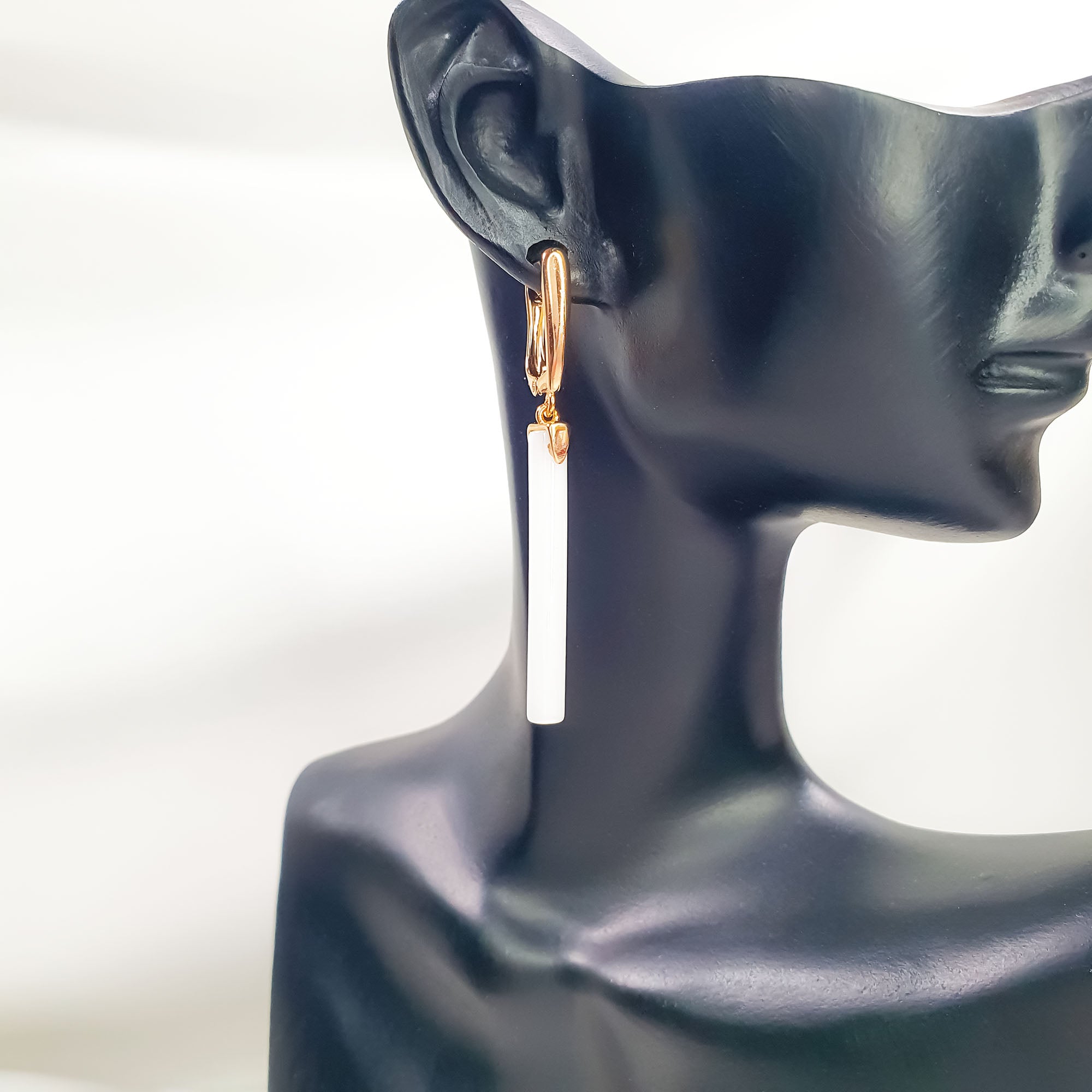 Zelta krāsas rotaslieta ar angļu aizdari un gludiem baltiem elementiem bez akmeņiem