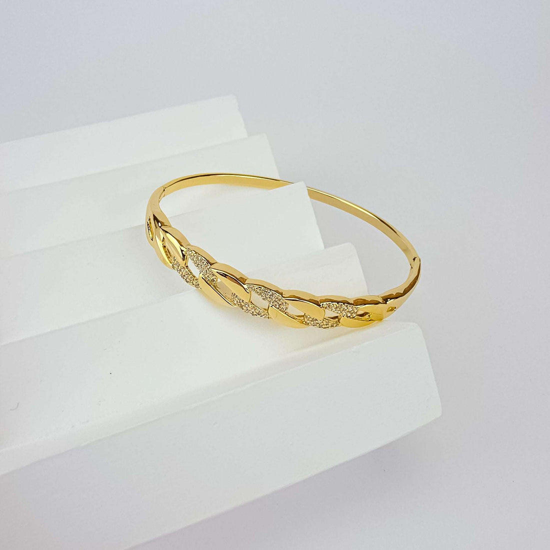 Kullatud jäik bangle käevõru ketilülide mustri ja sädelevate tsirkoonidega valgel alusel