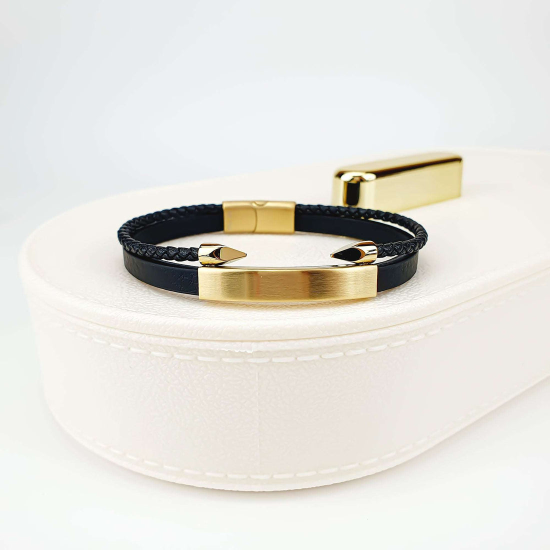Punutud ja sile nahkkäevõru kullatud plaadiga valgel ehtekarbil
